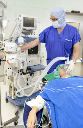 A medical professional with a patient in a surgical room